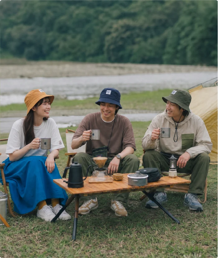 Three campers drinking coffee at an outdoor table wearing Yama Workwear Bucket Hats in mustard yellow, navy blue, and olive green from the Yama Series at Grandmama Store in Hong Kong.