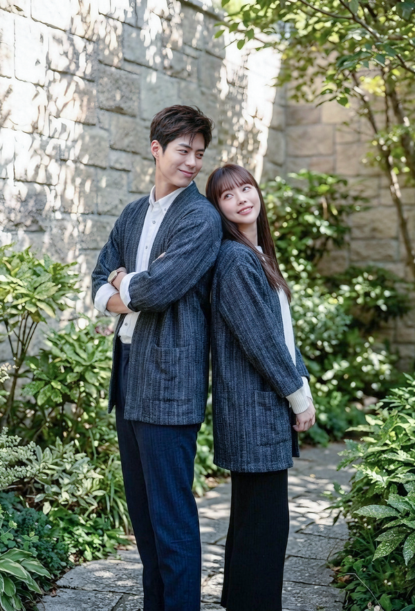A smiling man and woman standing A couple wearing matching Hand-cranked Kimonos in Miho Matsubara colorway standing back-to-back in a garden at Grandmama Store in Hong Kong.