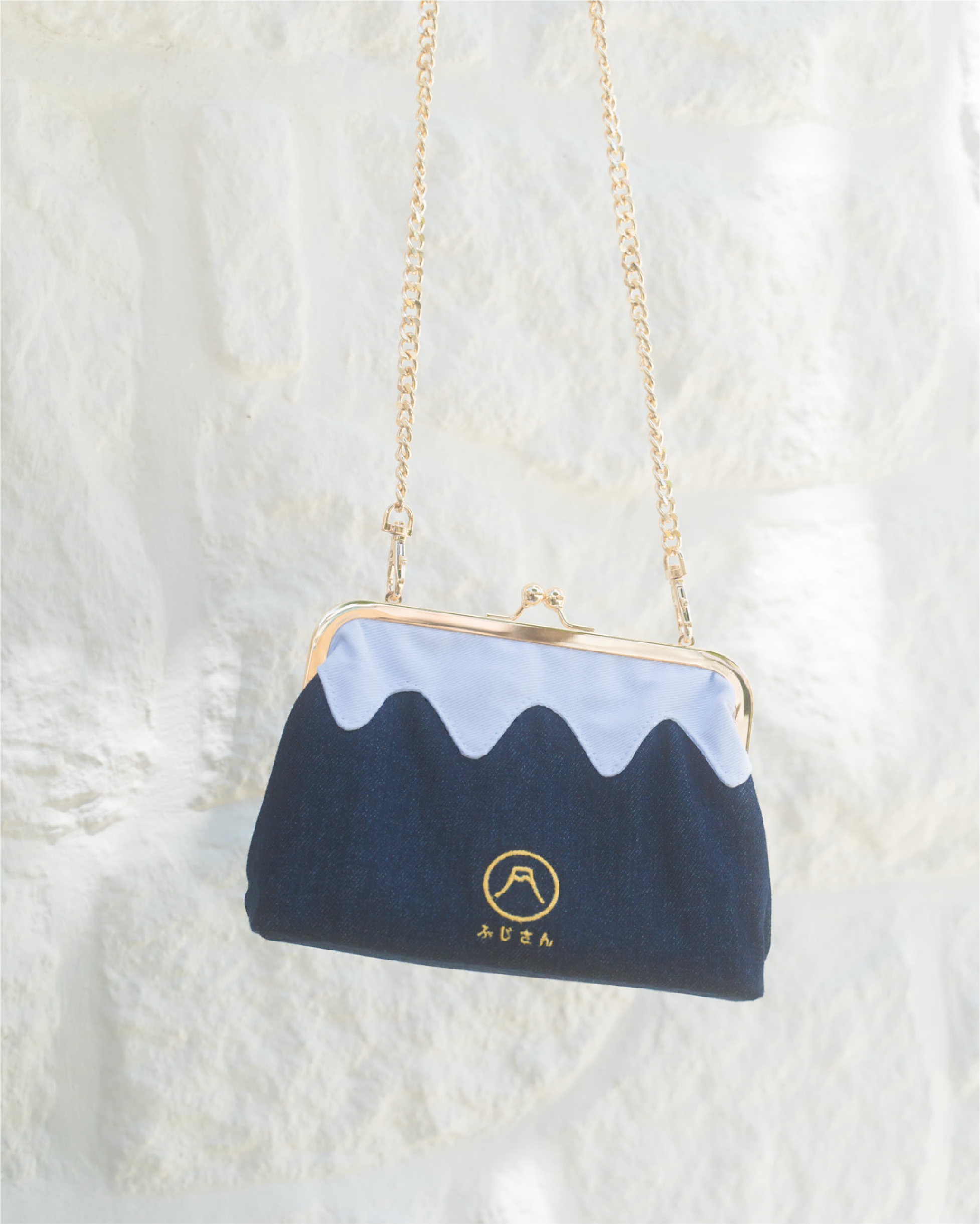 A dark blue Mt. Fuji Pocket Bag hanging against a white wall at Grandmama Store in Hong Kong.