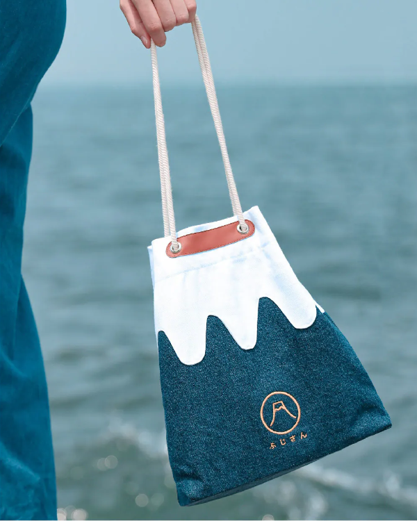 A handheld view of the blue and white Mt. Fuji sake bag by the sea at Grandmama Store in Hong Kong.