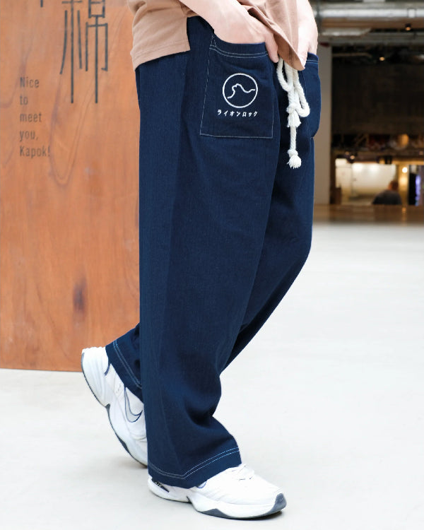 A model wearing dark navy blue Kamon Japanese Waist Rope Pants with the Lion Rock emblem at Grandmama Store in Hong Kong.