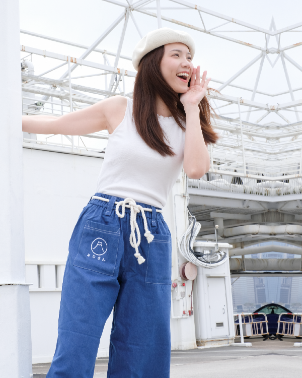 A smiling woman modeling Oxford blue Kamon Japanese Waist Rope Pants outdoors at Grandmama Store in Hong Kong.