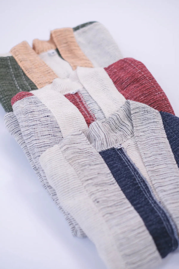 A stack of Hand-cranked Kids Kimono jackets in Mt. Fuji, Tokyo Tower, and Yakushima woven colorways at Grandmama Store in Hong Kong.