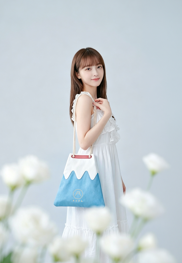 A woman in a white dress carrying a light blue Mt. Fuji sake bag over her shoulder at Grandmama Store in Hong Kong.