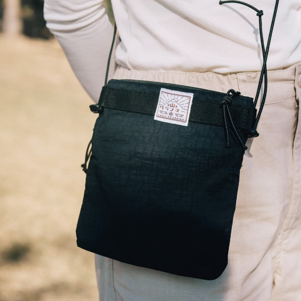 Back view of the Yama Multifunctional Bag｜Black worn cross-body outdoors at Grandmama Store in Hong Kong.
