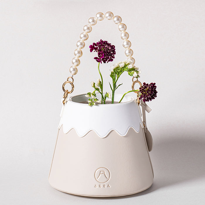 Beige Mt. Fuji Goen Bag in Tea with pearl strap holding a red rose at Grandmama Store in Hong Kong.