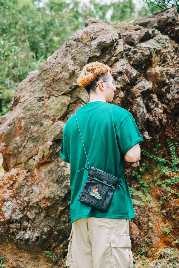 Black Yama Multifunctional Bag with embroidered boot patch worn outdoors at Grandmama Store in Hong Kong.
