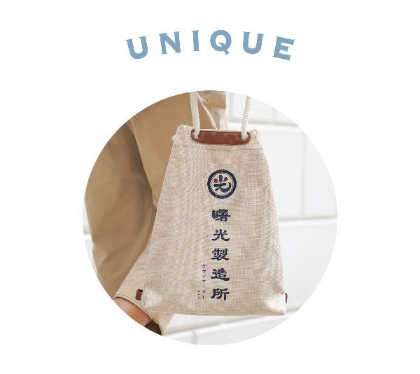 Circular graphic cutout of a person carrying the Light of Dawn Sake Bag in Linen at Grandmama Store in Hong Kong.