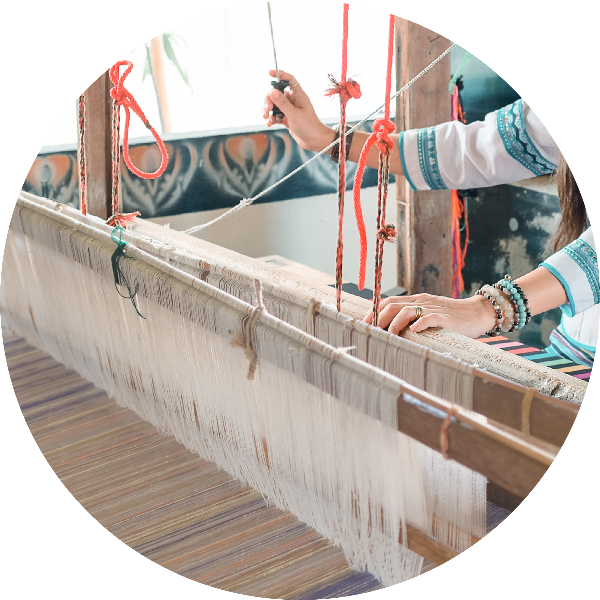 Close-up of an artisan hand-weaving fabric on a traditional wooden loom for Hand-cranked Kids Kimonos at Grandmama Store in Hong Kong.