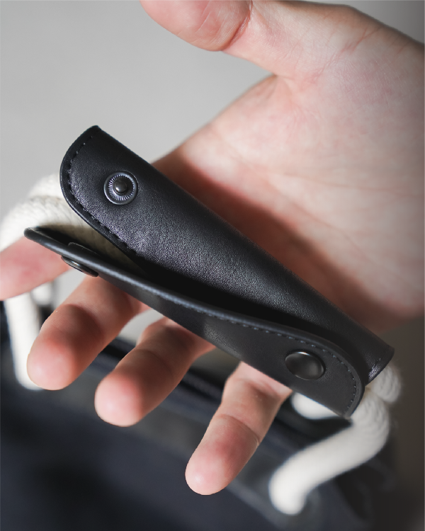 Close-up of black leather handle wrap detail on the Light of Dawn Sake Bag in Black Denim at Grandmama Store in Hong Kong.
