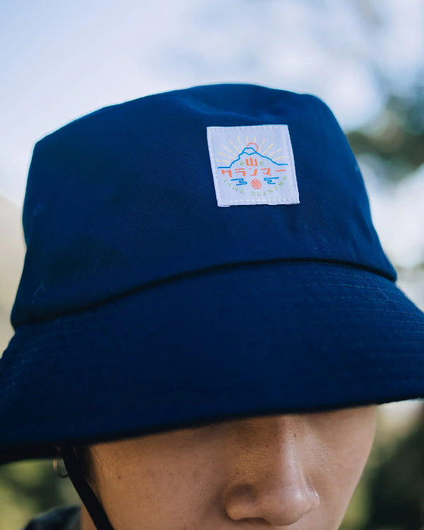 Close-up of the logo patch on the navy blue Yama Workwear Bucket Hat at Grandmama Store in Hong Kong.