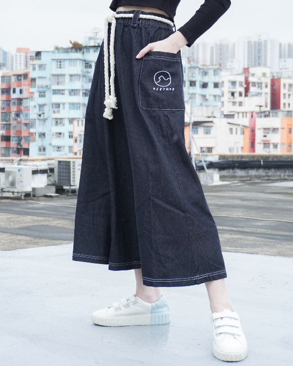 Close-up shot of the black Kamon Denim Dress with braided rope belt and embroidered pocket at Grandmama Store in Hong Kong.