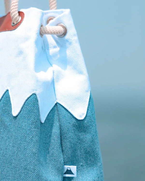 Close-up side view of a blue canvas Mt. Fuji sake bag showing the stitching and logo tag at Grandmama Store in Hong Kong.
