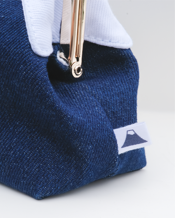 Close-up side view of the dark blue Mt. Fuji Pocket Bag with logo side tag at Grandmama Store in Hong Kong.