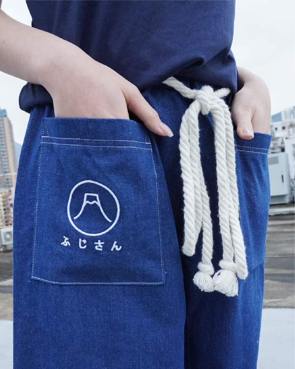 Close-up view of the Mt. Fuji embroidery and white rope belt on the Oxford blue Kamon Pants at Grandmama Store in Hong Kong.