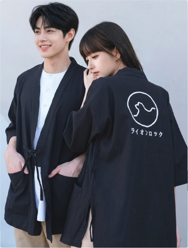 Couple posing in matching black Kamon Kimono Jacket-Lion Rock at Grandmama Store in Hong Kong