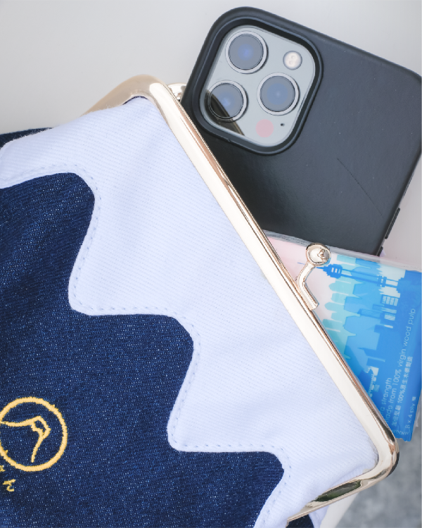 Demonstration of a smartphone fitting inside the dark blue Mt. Fuji Pocket Bag at Grandmama Store in Hong Kong.