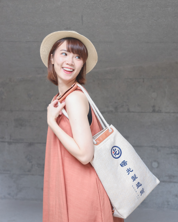 Female model carrying the Light of Dawn Sake Bag in Linen on her shoulder at Grandmama Store in Hong Kong.