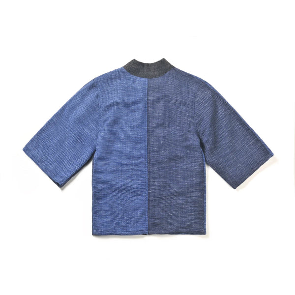 The back view of a panel-design Flat-lay back view of the Hand-cranked Kimono in showing textured dark navy blue and grey hand-woven fabric at Grandmama Store in Hong Kong.