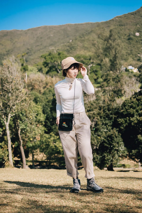 Full-body outdoor lifestyle shot of the black Yama Multifunctional Bag with boot patch at Grandmama Store in Hong Kong.