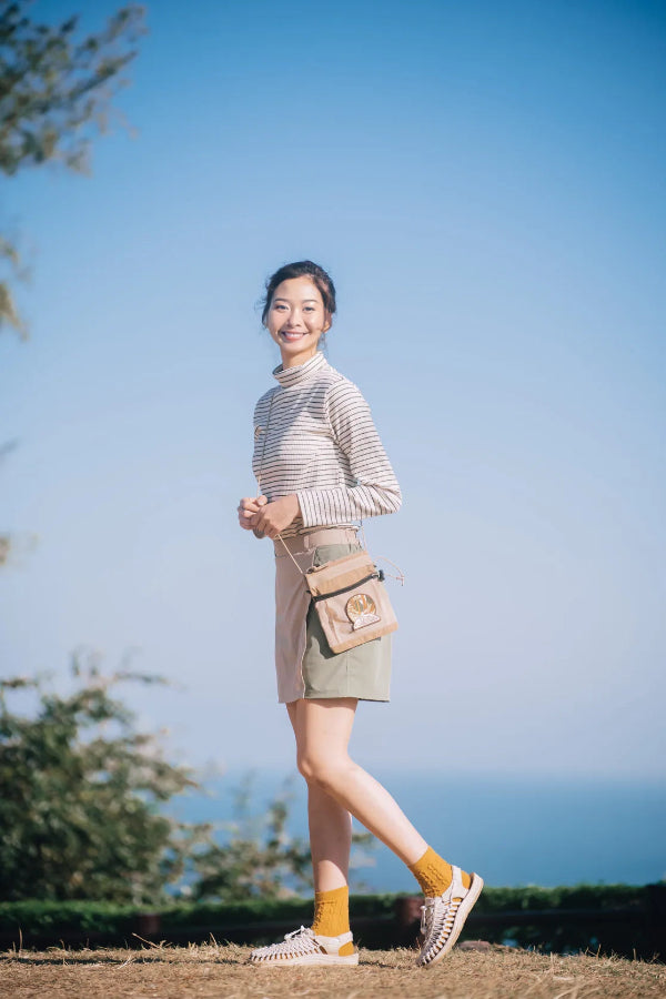 Full-body outdoor lifestyle shot of the light brown Yama Multifunctional Bag at Grandmama Store in Hong Kong.