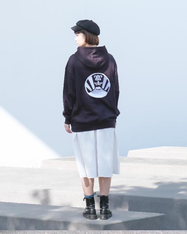 Full-length back view of a female model wearing the dark purple Fujisan Kamon Hoodie at Grandmama Store in Hong Kong.