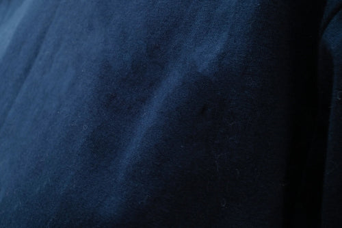 Macro close-up shot of the dark navy blue cotton fabric texture for the Kamon Tee at Grandmama Store in Hong Kong.