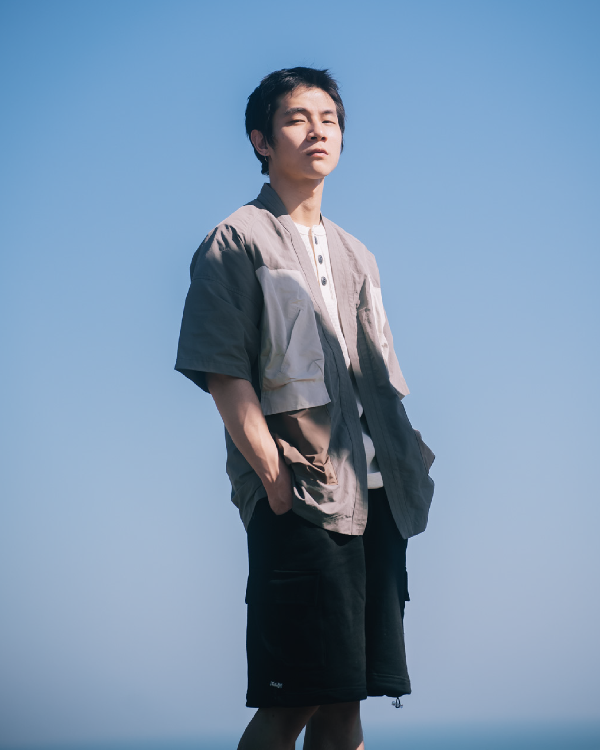 Male model wearing greyish Morikawa Yama Kimono Jacket outdoors at Grandmama Store in Hong Kong.