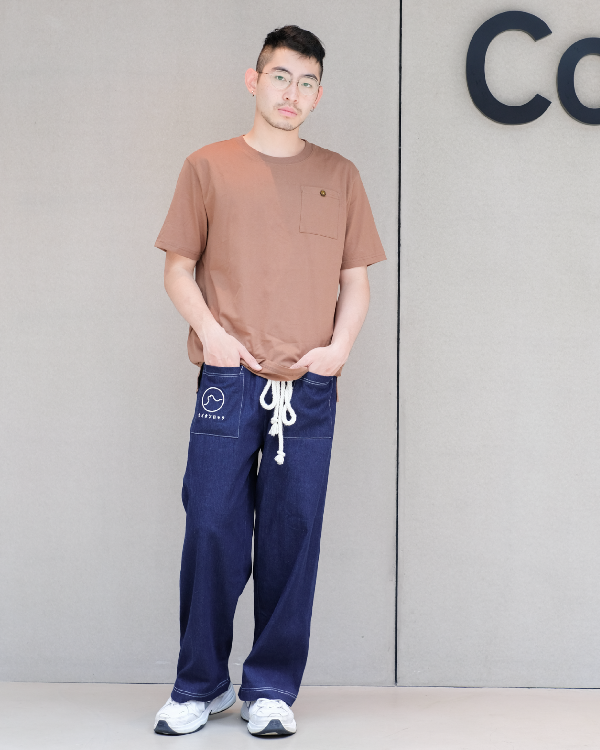 Male model wearing navy blue Kamon Japanese Waist Rope Pants with Lion Rock patch against a grey wall at Grandmama Store in Hong Kong.