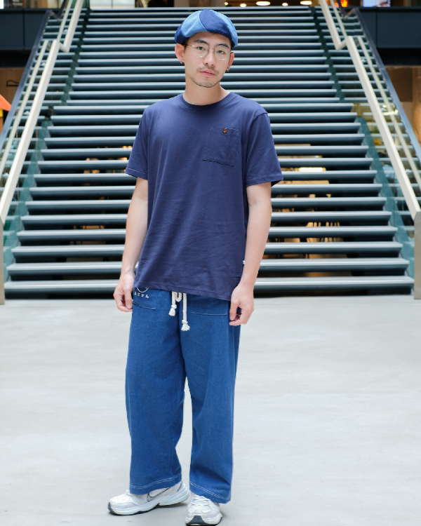 Male model wearing navy blue Kamon Japanese Waist Rope Pants with white rope tie standing in front of stairs at Grandmama Store in Hong Kong.