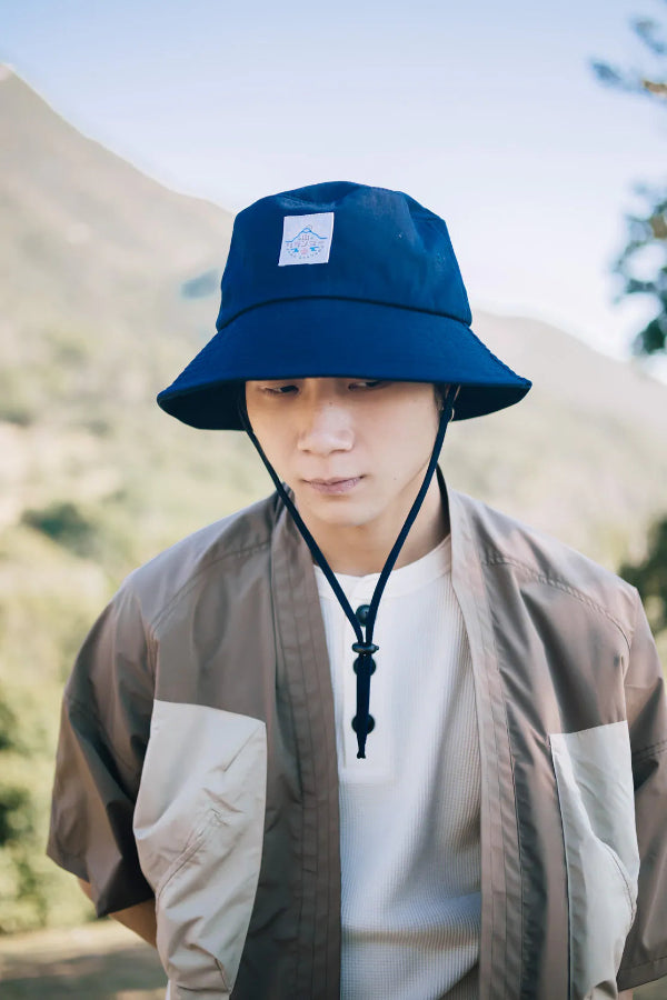 Man wearing the navy blue Yama Workwear Bucket Hat outdoors at Grandmama Store in Hong Kong.