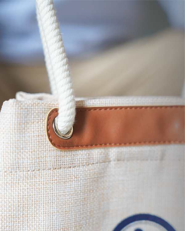 Metal eyelet grommet and leather trim detail on the Light of Dawn Sake Bag in Linen at Grandmama Store in Hong Kong.