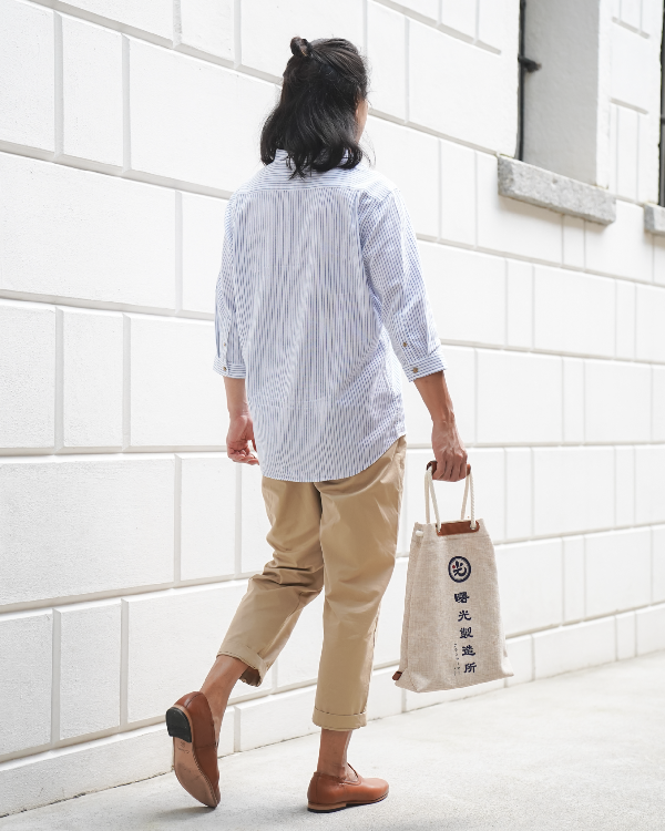 Model carrying the Light of Dawn Sake Bag in Linen while walking at Grandmama Store in Hong Kong.