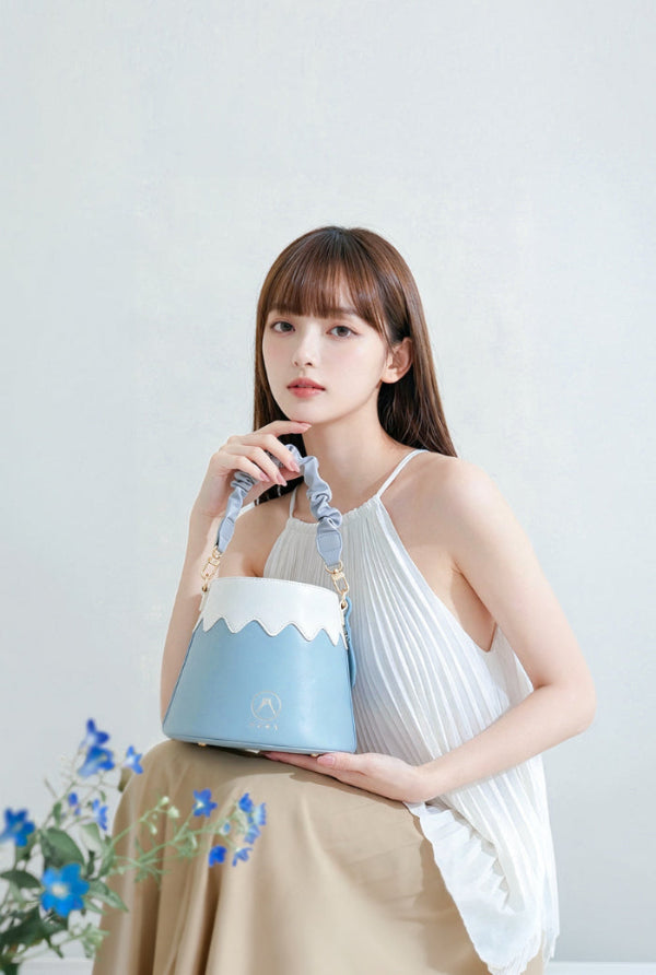 Model holding the sky blue Mt. Fuji Goen Bag with a ruffled scrunchie handle at Grandmama Store in Hong Kong.