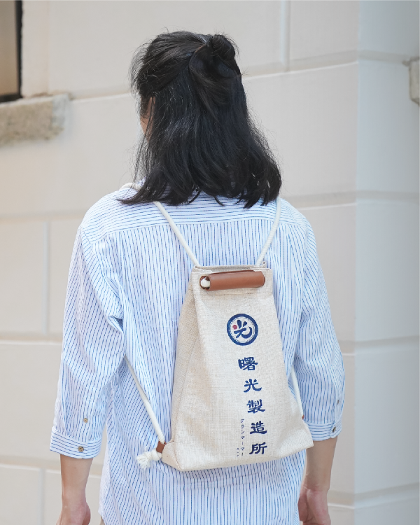 Model wearing the Light of Dawn Sake Bag in Linen as a backpack at Grandmama Store in Hong Kong.