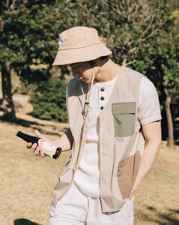 Model wearing the beige Yama Workwear Bucket Hat outdoors at Grandmama Store in Hong Kong.