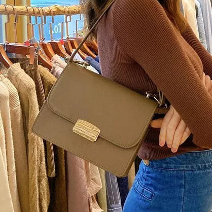 Model wearing the taupe Square Side Bag with Gold Buckle on her shoulder at Grandmama Store in Hong Kong.