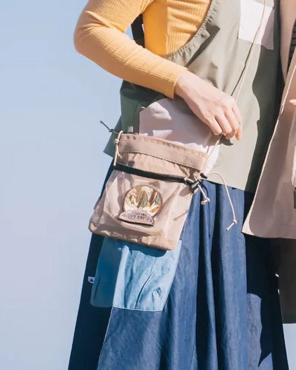 Reaching into the light brown Yama Multifunctional Bag at Grandmama Store in Hong Kong.