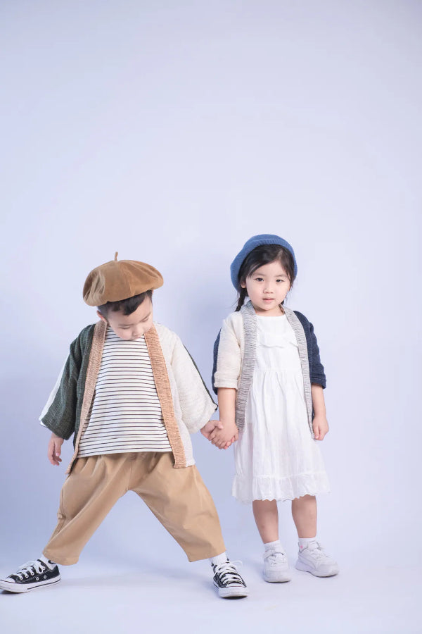 Two children modeling Hand-cranked Kids Kimono jackets in Yakushima green and Mt. Fuji blue colorways at Grandmama Store in Hong Kong.