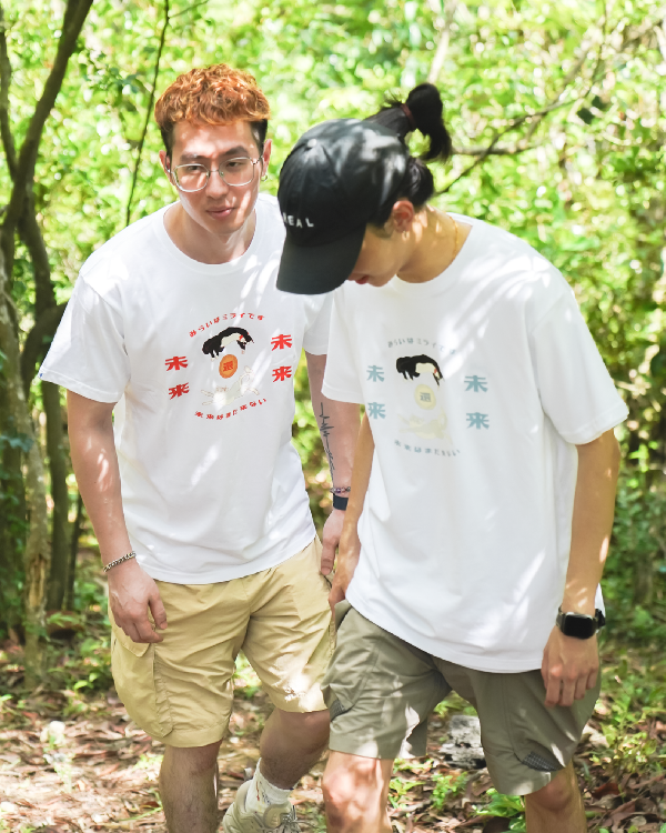 Two models wearing white Lazy Cat Tees on an outdoor nature trail at Grandmama Store in Hong Kong.