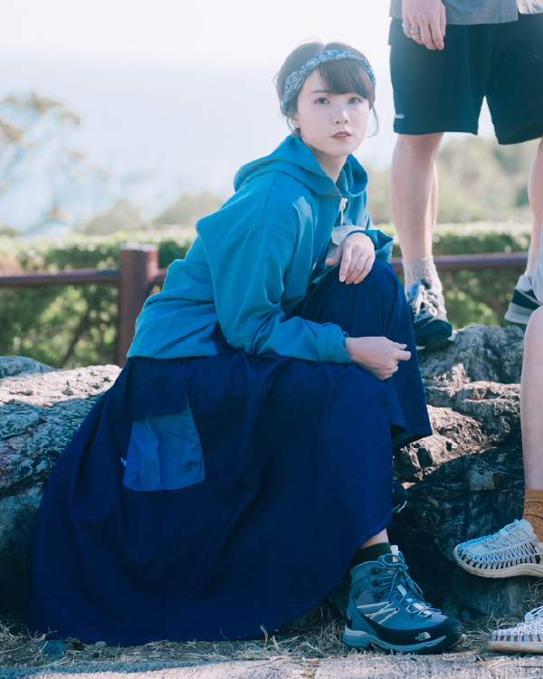 Woman crouching outdoors in the dark blue Yama Ocean Pocket Dress at Grandmama Store in Hong Kong.