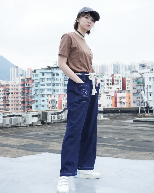 Woman modeling navy blue Kamon Japanese Waist Rope Pants with Lion Rock patch on a rooftop at Grandmama Store in Hong Kong.