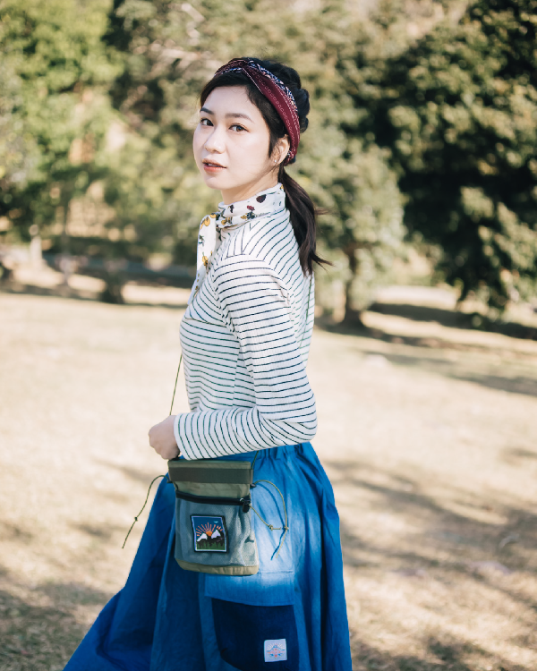 Woman styled in the light blue Yama Ocean Pocket Dress with a crossbody pouch outdoors at Grandmama Store in Hong Kong.