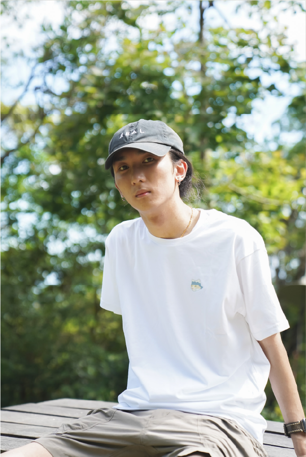 man-in-cap-sitting-outdoors-front-view-wearing-white-festival-cat-tee-Hong-Kong-Kwun-Tong-Grandmama-store