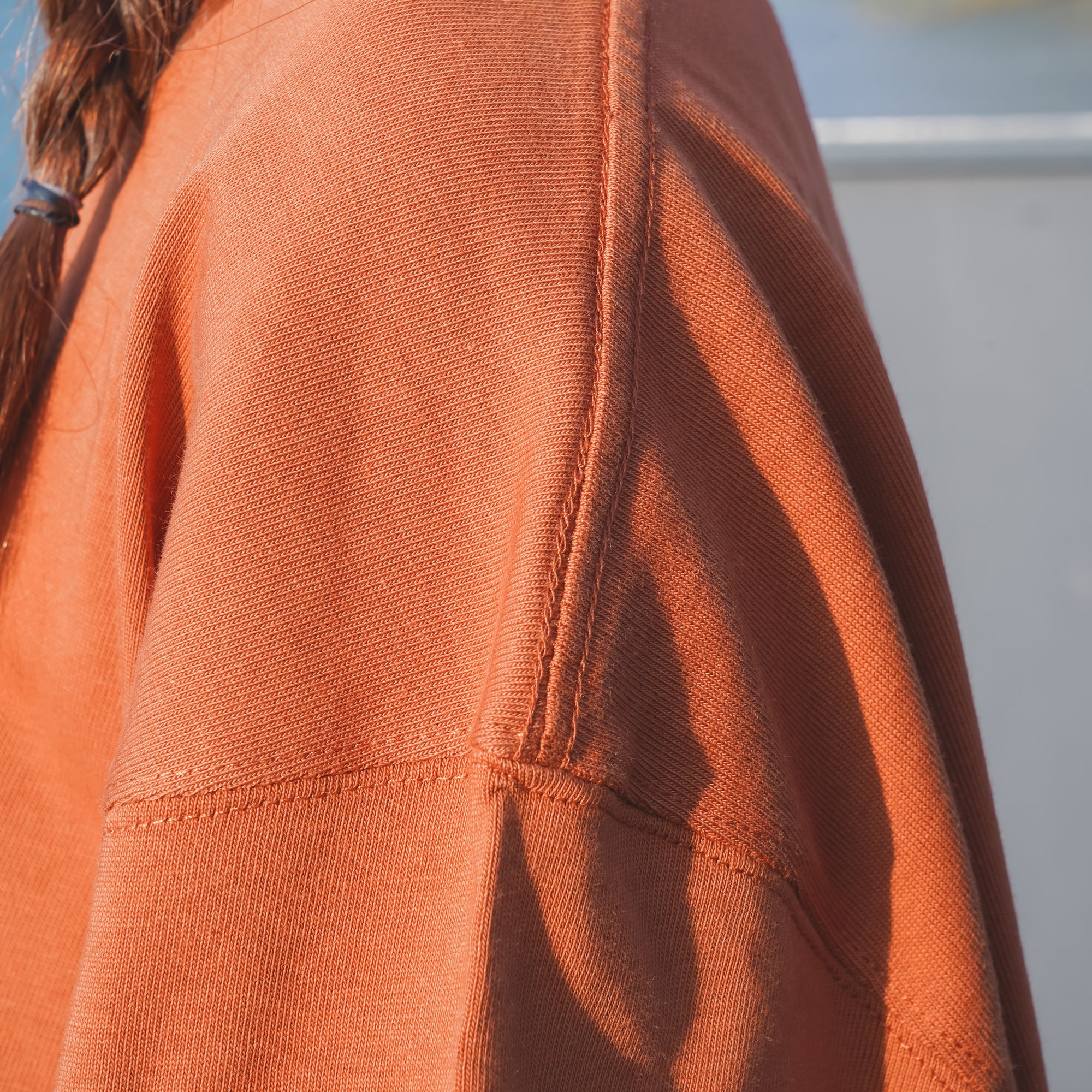 Terracotta orange Yama Basic Color Tee shoulder seam detail at Grandmama Store in Hong Kong.