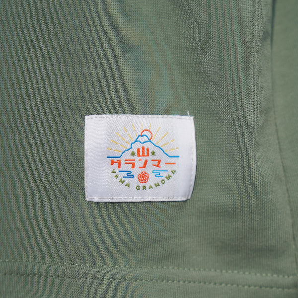 Woven brand logo patch on olive green Yama Basic Color Tee at Grandmama Store in Hong Kong.